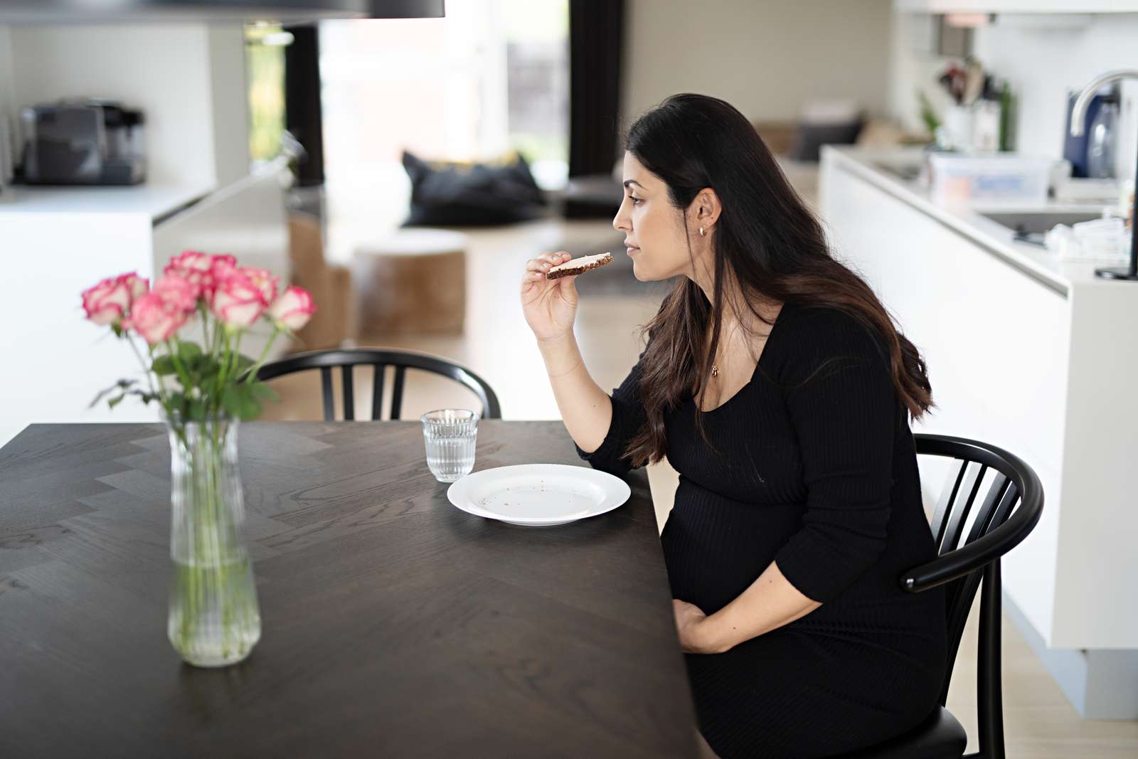 Billede af en gravid kvinde, der spiser en rugbrødsmad.