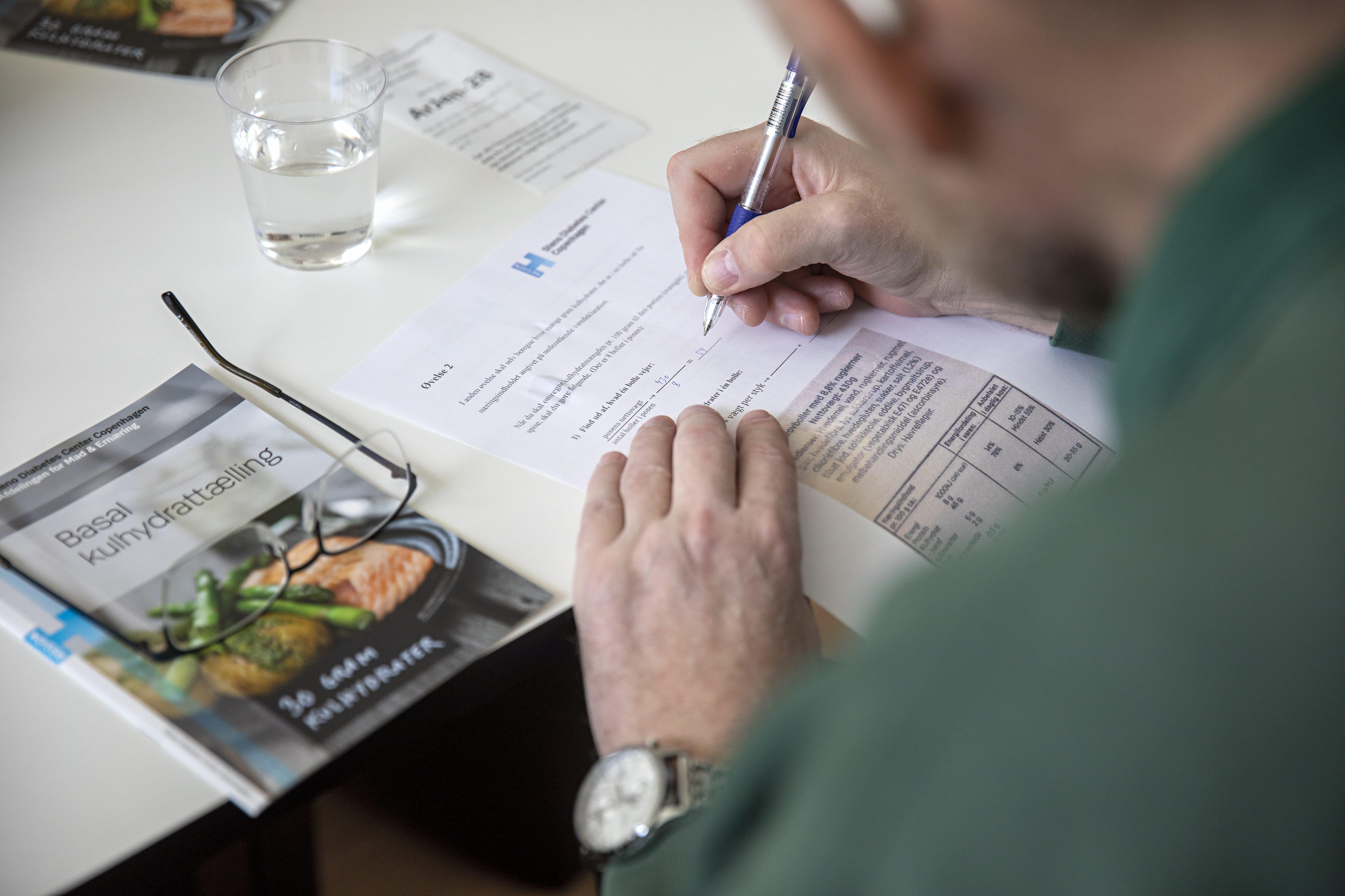 Billede af en mand, der beregner hvor meget insulin der skal gives ud fra mængden af kulhydrater.