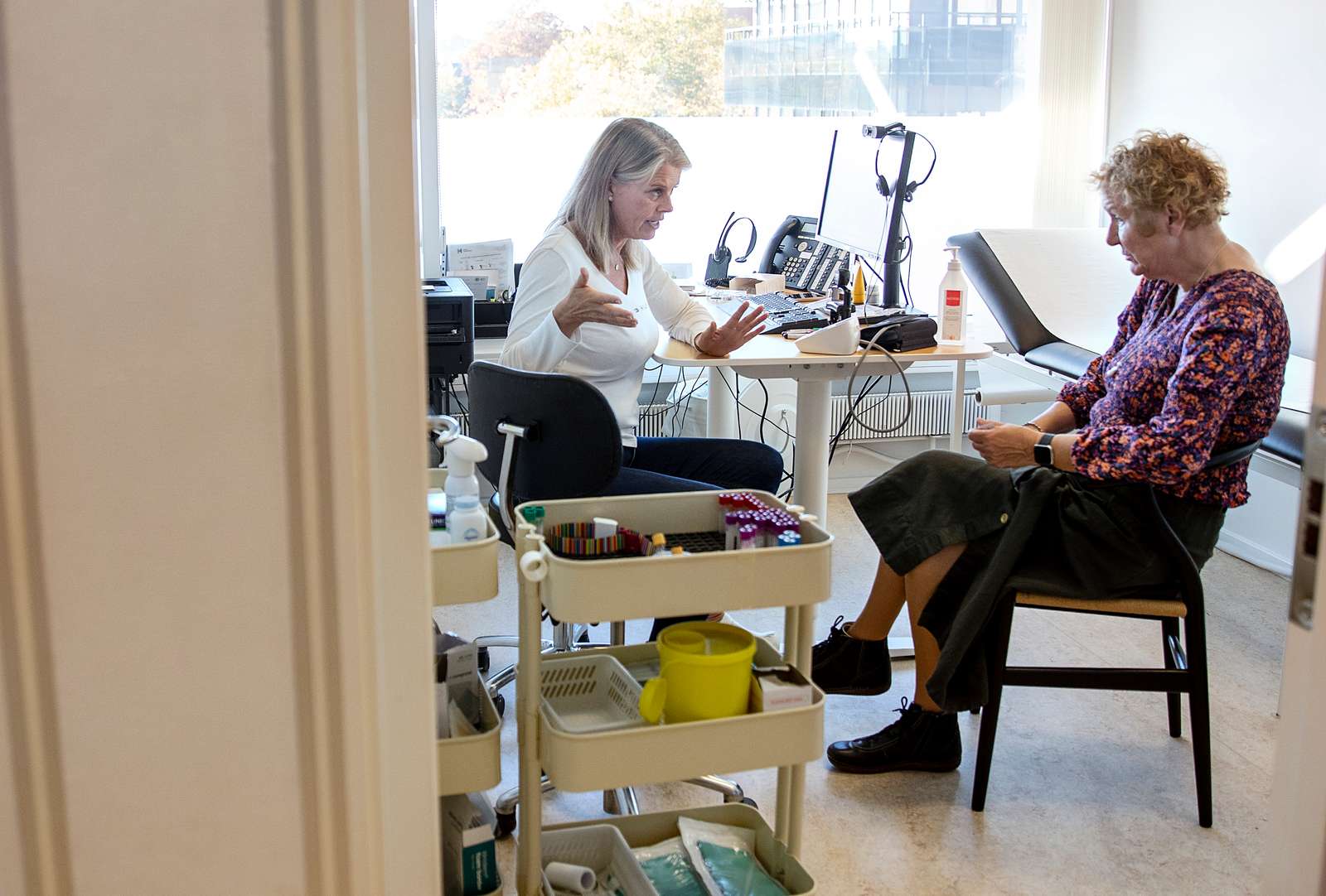 Billede af privatpraktiserende læge og en borger.