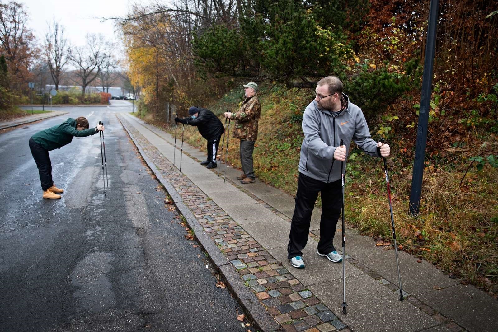 Billede af fire personer, der træner med gangstave udendørs