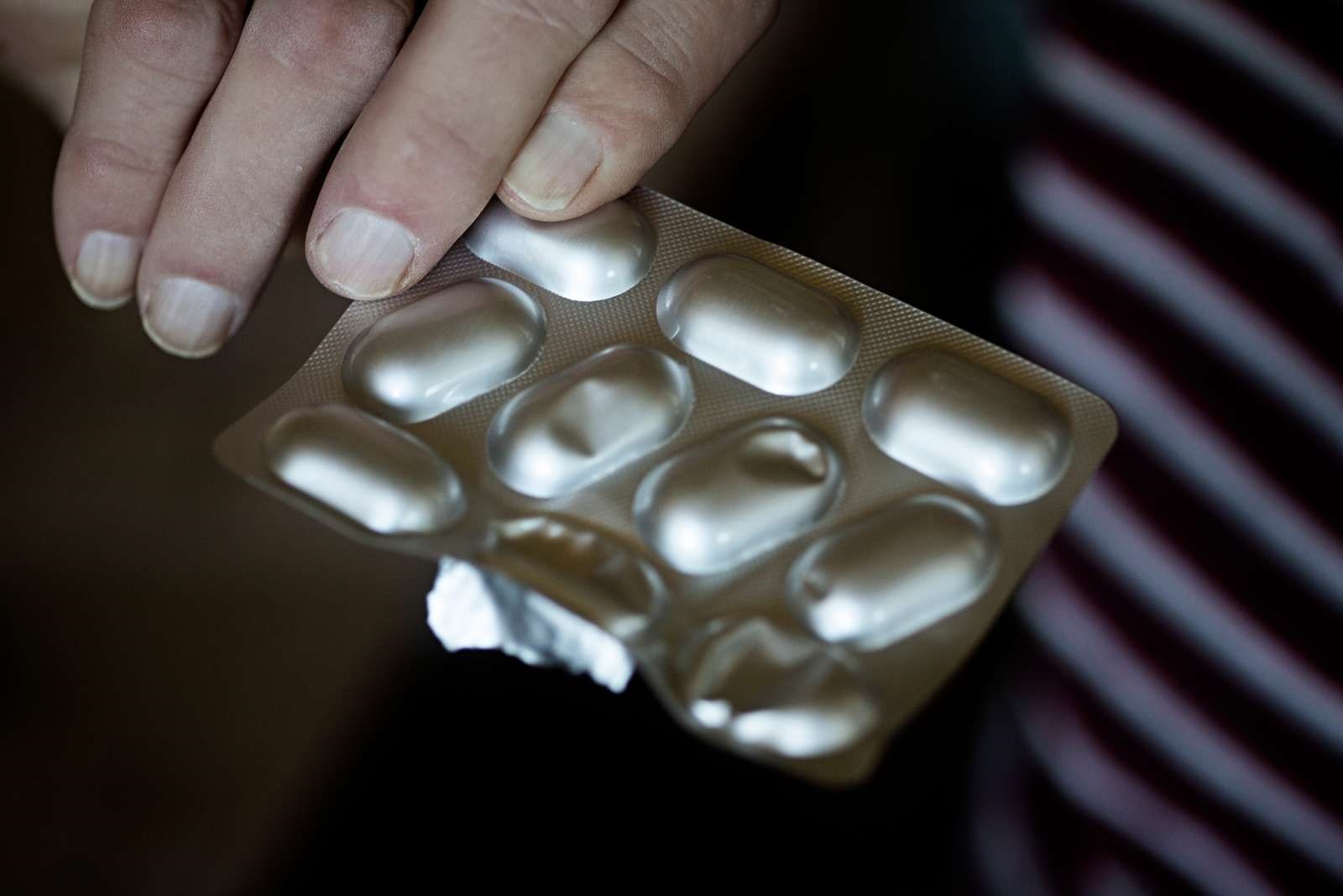 Billede af en hånd og en pakke piller