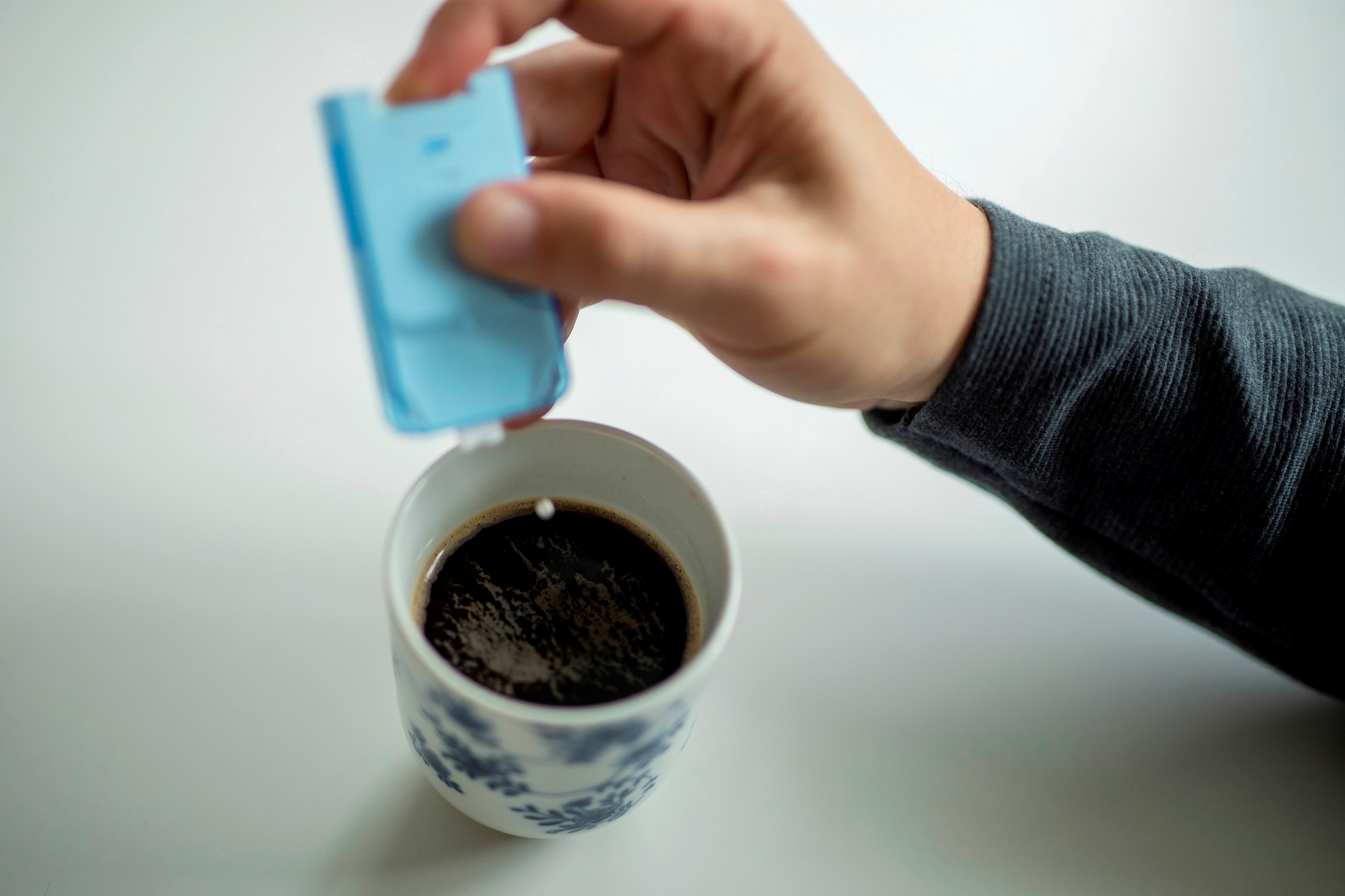 Billede af en sødetablet der puttes i en kop kaffe