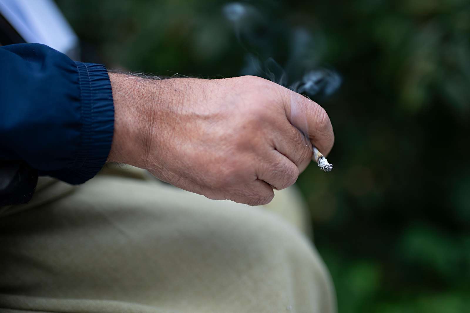 Billede af en hånd, der holder en cigaret.