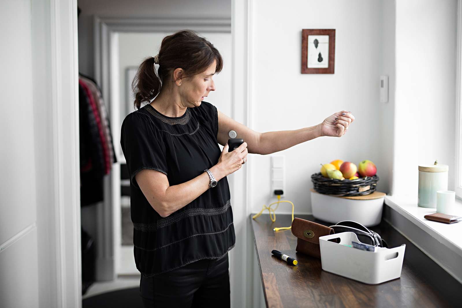 En kvinde med glukosemåler på armen scanner sin sensor
